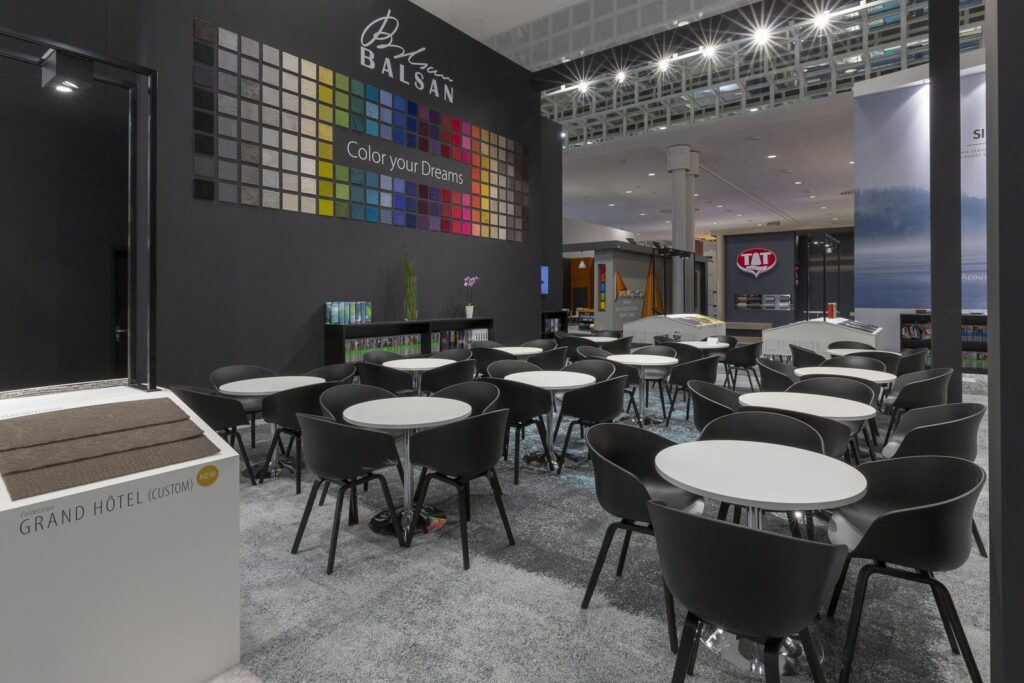 Black chairs and round white tables in the Balsan stand lounge at Domotex 2019