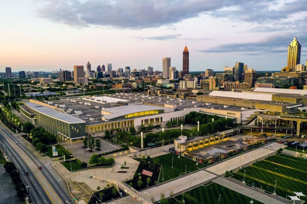 Aerial view of the Georgia World Congress Center complex and Atlanta skyline at dusk