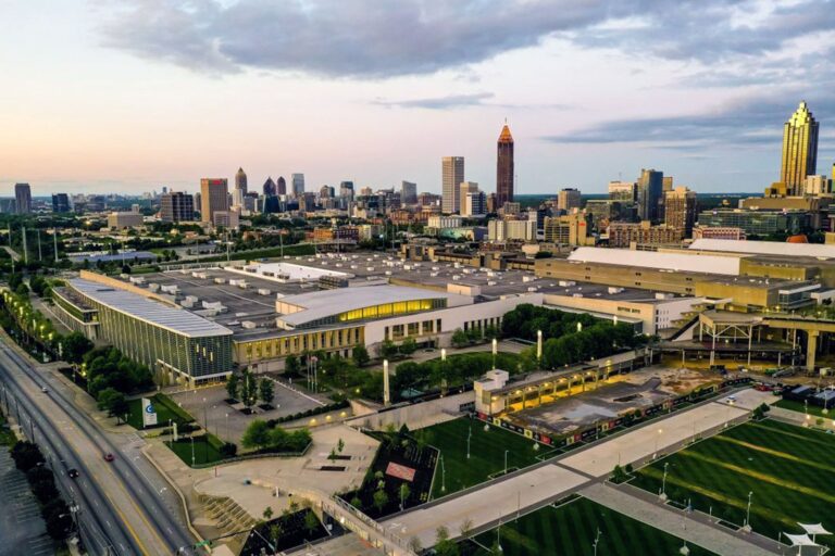 Aerial view of the Georgia World Congress Center complex and Atlanta skyline at dusk