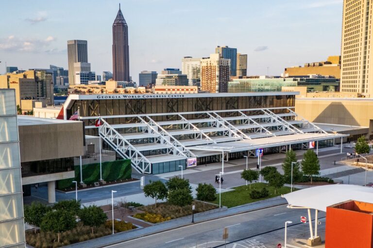 Georgia World Congress Center building front with the Atlanta skyline behind
