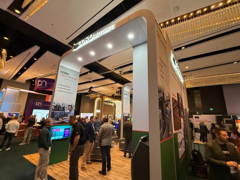 Cord ATM stand with curved white arches, wood-effect floor and visitors in a Las Vegas ballroom hall